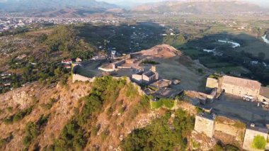 Arnavutluk 'un Şkoder kentindeki Rozafa Kalesi' nin antik taş duvarları ve kalıntılarının insansız hava aracı görüntüsü. Ortaçağ kalesi ve nehir ve dağ manzarasının hava perspektifi görüntüleri.