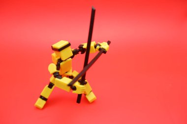 Kırmızı Arkaplanda Çift Kılıçlı Oyuncak Eylem Figürü Pozisyonu