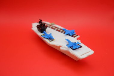 Mavi Jet Uçaklı Mini Savaş Gemisi Oyuncak Kırmızı Yüzeyde Gösterildi