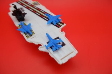 Mavi Jet Uçaklı Mini Savaş Gemisi Oyuncak Kırmızı Yüzeyde Gösterildi