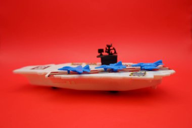 Mavi Jet Uçaklı Mini Savaş Gemisi Oyuncak Kırmızı Yüzeyde Gösterildi