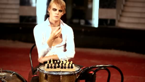 Mand spiller skak sidder ved tromlen – Stock-video