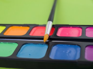 Bir fırça ile sulu boya parlak renkler yeşil arka plan kapatın