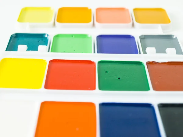 Acuarela colores brillantes con un cepillo primer plano fondo blanco — Foto de Stock