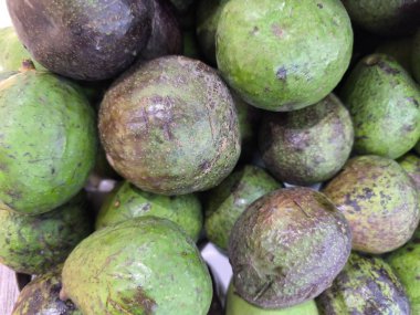 Sayısız taze avokado yeşilin ve morun değişik tonlarını gösterir. Bu da olgunluğun farklı aşamalarını gösterir. Sağlıklı, doğal bir yiyecek seçeneği.