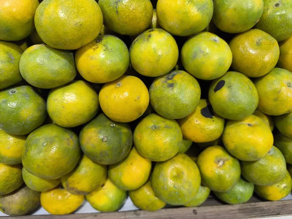 Canlı yeşilden zengin sarı renklere kadar doğal spektrumlarını sergileyen taze toplanmış portakalların görüntüsü.