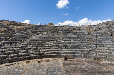 Landscape shot in the Andalusian summer. Barren landscape with blue sky next to Roman ruins. An old, dilapidated historical theater at the ruins of Acinipo, Andalusia, Spain
