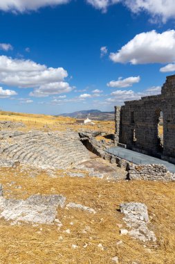 Landscape shot in the Andalusian summer. Barren landscape with blue sky next to Roman ruins. An old, dilapidated historical theater at the ruins of Acinipo, Andalusia, Spain