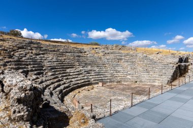Landscape shot in the Andalusian summer. Barren landscape with blue sky next to Roman ruins. An old, dilapidated historical theater at the ruins of Acinipo, Andalusia, Spain