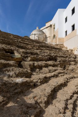 Şehrin ortasında evlerle çevrili eski bir tarihi tiyatro. Bu dönüm noktası gündüz çekilmiş. Teatro Romano de Cdiz, Endülüs, İspanya