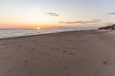 Sahilde nefes kesici bir gün batımı. Ufuktaki denizin üzerinde batan güneşin kumsalını seyret. Atlantik kıyısında Rota, Costa de la Lutz, Cdiz, Endülüs, İspanya yakınlarındaki manzara görüntüleri.