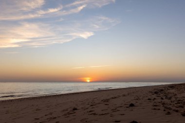 Sahilde nefes kesici bir gün batımı. Ufuktaki denizin üzerinde batan güneşin kumsalını seyret. Atlantik kıyısında Rota, Costa de la Lutz, Cdiz, Endülüs, İspanya yakınlarındaki manzara görüntüleri.