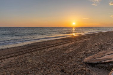 Sahilde nefes kesici bir gün batımı. Ufuktaki denizin üzerinde batan güneşin kumsalını seyret. Atlantik kıyısında Rota, Costa de la Lutz, Cdiz, Endülüs, İspanya yakınlarındaki manzara görüntüleri.