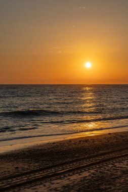 Sahilde nefes kesici bir gün batımı. Ufuktaki denizin üzerinde batan güneşin kumsalını seyret. Atlantik kıyısında Rota, Costa de la Lutz, Cdiz, Endülüs, İspanya yakınlarındaki manzara görüntüleri.