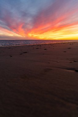 Sahilde nefes kesici bir gün batımı. Gökyüzü en güzel renklerle parıldıyor. Sahilden denize ve ufuk çizgisine bakın Rota, Costa de la Lutz, Cdiz, Endülüs, İspanya.