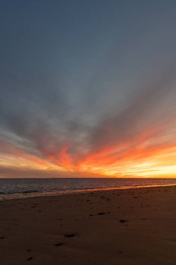 Sahilde nefes kesici bir gün batımı. Gökyüzü en güzel renklerle parıldıyor. Sahilden denize ve ufuk çizgisine bakın Rota, Costa de la Lutz, Cdiz, Endülüs, İspanya.
