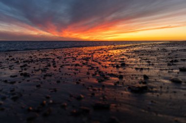 Sahilde nefes kesici bir gün batımı. Gökyüzü en güzel renklerle parıldıyor. Sahilden denize ve ufuk çizgisine bakın Rota, Costa de la Lutz, Cdiz, Endülüs, İspanya.