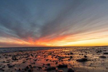Sahilde nefes kesici bir gün batımı. Gökyüzü en güzel renklerle parıldıyor. Sahilden denize ve ufuk çizgisine bakın Rota, Costa de la Lutz, Cdiz, Endülüs, İspanya.