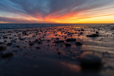 Sahilde nefes kesici bir gün batımı. Gökyüzü en güzel renklerle parıldıyor. Sahilden denize ve ufuk çizgisine bakın Rota, Costa de la Lutz, Cdiz, Endülüs, İspanya.