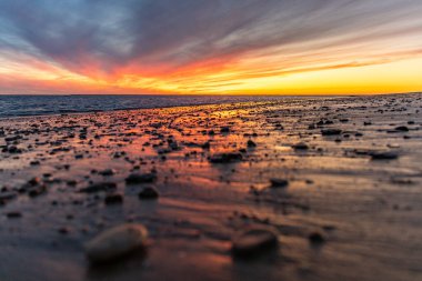 Sahilde nefes kesici bir gün batımı. Gökyüzü en güzel renklerle parıldıyor. Sahilden denize ve ufuk çizgisine bakın Rota, Costa de la Lutz, Cdiz, Endülüs, İspanya.
