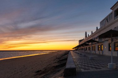 Sahilde nefes kesici bir gün batımı. Gökyüzü en güzel renklerle parıldıyor. Sahilden denize ve ufuk çizgisine bakın Rota, Costa de la Lutz, Cdiz, Endülüs, İspanya.