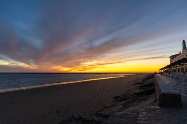 Sahilde nefes kesici bir gün batımı. Gökyüzü en güzel renklerle parıldıyor. Sahilden denize ve ufuk çizgisine bakın Rota, Costa de la Lutz, Cdiz, Endülüs, İspanya.