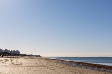 Güzel, güzel, geniş kumlu bir sahil, Atlantik kıyısında ıssız. Gökyüzü manzarası ve Rota 'ya doğru, Playa de la Costilla' da güneş ışığı, Costa de la Luz, Cdiz, Endülüs, İspanya.