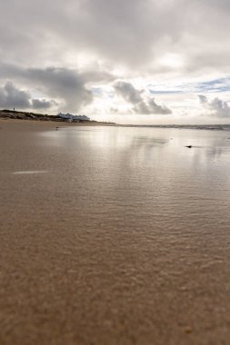 A beautiful, fine, wide sandy beach, deserted on the Atlantic coast. View of the skyline and towards Rota, cloudy sky at Playa de la Costilla, Costa de la Luz, Cadiz, Andalusia, Spain.anien.