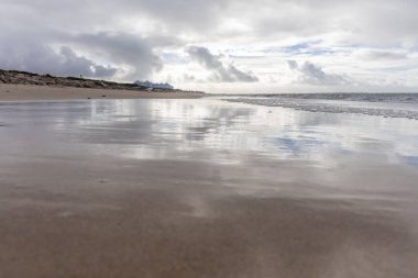 Güzel, güzel, geniş kumlu bir sahil, Atlantik kıyısında ıssız. Gökyüzü Rota 'ya doğru, bulutlu gökyüzü Playa de la Costilla, Costa de la Luz, Cadiz, Endülüs, İspanya.