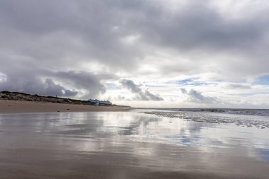 Güzel, güzel, geniş kumlu bir sahil, Atlantik kıyısında ıssız. Gökyüzü Rota 'ya doğru, bulutlu gökyüzü Playa de la Costilla, Costa de la Luz, Cadiz, Endülüs, İspanya.