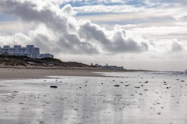Güzel, güzel, geniş kumlu bir sahil, Atlantik kıyısında ıssız. Gökyüzü Rota 'ya doğru, bulutlu gökyüzü Playa de la Costilla, Costa de la Luz, Cadiz, Endülüs, İspanya.