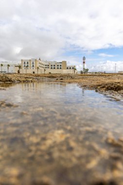 Güzel, güzel, geniş kumlu bir sahil, Atlantik kıyısında ıssız. Gökyüzü manzarası ve Rota 'ya doğru, Playa de la Costilla' da güneş ışığı, Costa de la Luz, Cdiz, Endülüs, İspanya.