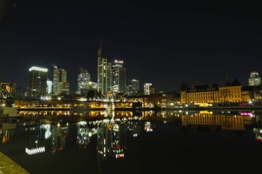 Şehir manzarası ve modern bir metropolün ufuk çizgisi. Geceleyin ve şafak vakti Frankfurt am Main, Hesse, Almanya 'daki aydınlık pencere ve cephelerin görüntüsü.