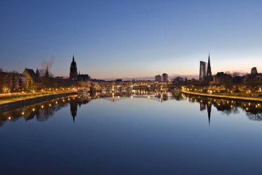 Şehir manzarası ve modern bir metropolün ufuk çizgisi. Geceleyin ve şafak vakti Frankfurt am Main, Hesse, Almanya 'daki aydınlık pencere ve cephelerin görüntüsü.