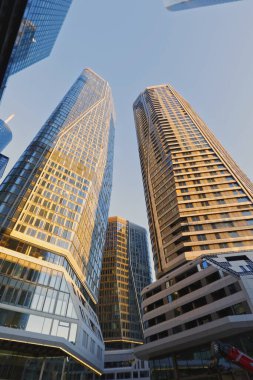 Şehir ve gökyüzü modern bir metropolün manzarası. Sabah alacakaranlıkta gökdelenlerin arasından yukarıya bakıyor. Frankfurt am Main, Hesse, Almanya 'da pencere ve cepheler.