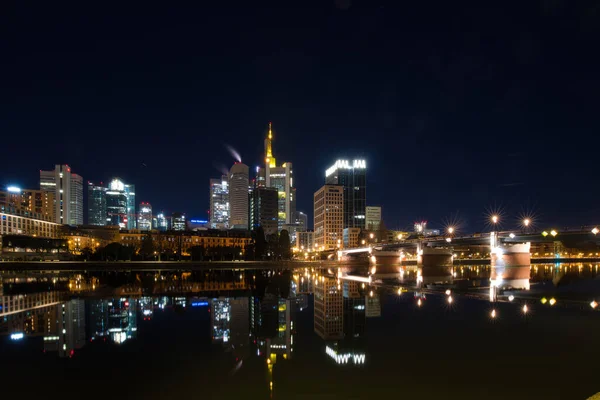 Şehir manzarası ve modern bir metropolün ufuk çizgisi. Geceleyin ve şafak vakti Frankfurt am Main, Hesse, Almanya 'daki aydınlık pencere ve cephelerin görüntüsü.