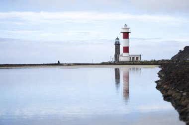 Eski ve yeni Fuencaliente deniz fenerlerinin simetrik yansıması Salinas, La Palma, Kanarya Adaları 'ndaki tuz buharlaşma havuzlarında