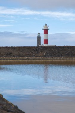 Eski ve yeni Fuencaliente deniz fenerlerinin simetrik yansıması Salinas, La Palma, Kanarya Adaları 'ndaki tuz buharlaşma havuzlarında