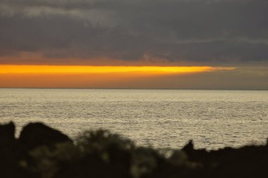 Güneş doğarken eşsiz bir hava durumu fenomeni: Tenerife 'deki Teide volkanının gölgesi, İspanya' nın Kanarya Adaları 'ndaki La Palma adasının lav kıyılarından gözlemlenen denizin üzerinde yoğun bir bulut örtüsüne karşı aşağıdan yansıtılır..