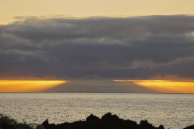 Güneş doğarken eşsiz bir hava durumu fenomeni: Tenerife 'deki Teide volkanının gölgesi, İspanya' nın Kanarya Adaları 'ndaki La Palma adasının lav kıyılarından gözlemlenen denizin üzerinde yoğun bir bulut örtüsüne karşı aşağıdan yansıtılır..