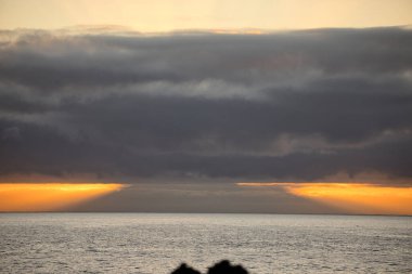 Güneş doğarken eşsiz bir hava durumu fenomeni: Tenerife 'deki Teide volkanının gölgesi, İspanya' nın Kanarya Adaları 'ndaki La Palma adasının lav kıyılarından gözlemlenen denizin üzerinde yoğun bir bulut örtüsüne karşı aşağıdan yansıtılır..