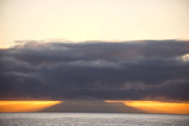 Güneş doğarken eşsiz bir hava durumu fenomeni: Tenerife 'deki Teide volkanının gölgesi, İspanya' nın Kanarya Adaları 'ndaki La Palma adasının lav kıyılarından gözlemlenen denizin üzerinde yoğun bir bulut örtüsüne karşı aşağıdan yansıtılır..