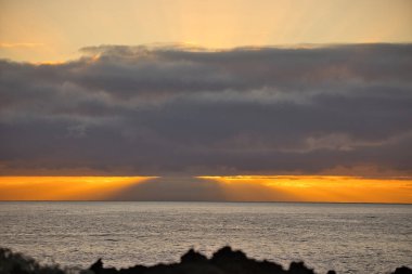 Güneş doğarken eşsiz bir hava durumu fenomeni: Tenerife 'deki Teide volkanının gölgesi, İspanya' nın Kanarya Adaları 'ndaki La Palma adasının lav kıyılarından gözlemlenen denizin üzerinde yoğun bir bulut örtüsüne karşı aşağıdan yansıtılır..