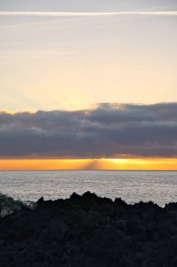 Güneş doğarken eşsiz bir hava durumu fenomeni: Tenerife 'deki Teide volkanının gölgesi, İspanya' nın Kanarya Adaları 'ndaki La Palma adasının lav kıyılarından gözlemlenen denizin üzerinde yoğun bir bulut örtüsüne karşı aşağıdan yansıtılır..