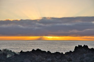 Güneş doğarken eşsiz bir hava durumu fenomeni: Tenerife 'deki Teide volkanının gölgesi, İspanya' nın Kanarya Adaları 'ndaki La Palma adasının lav kıyılarından gözlemlenen denizin üzerinde yoğun bir bulut örtüsüne karşı aşağıdan yansıtılır..