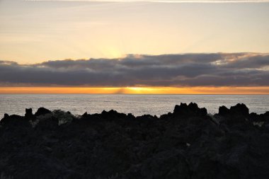 Güneş doğarken eşsiz bir hava durumu fenomeni: Tenerife 'deki Teide volkanının gölgesi, İspanya' nın Kanarya Adaları 'ndaki La Palma adasının lav kıyılarından gözlemlenen denizin üzerinde yoğun bir bulut örtüsüne karşı aşağıdan yansıtılır..