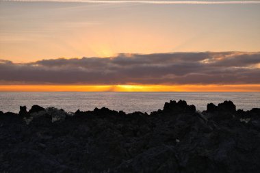Güneş doğarken eşsiz bir hava durumu fenomeni: Tenerife 'deki Teide volkanının gölgesi, İspanya' nın Kanarya Adaları 'ndaki La Palma adasının lav kıyılarından gözlemlenen denizin üzerinde yoğun bir bulut örtüsüne karşı aşağıdan yansıtılır..