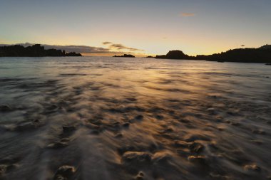 Los Cancajos sahilinde gün doğumunda uzun süre çekim, yumuşak su Atlantik kıyısında volkanik kayalara çarpıyor, La Palma, Kanarya Adaları, İspanya