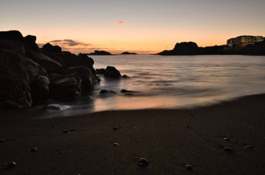 Los Cancajos sahilinde gün doğumunda uzun süre çekim, yumuşak su Atlantik kıyısında volkanik kayalara çarpıyor, La Palma, Kanarya Adaları, İspanya