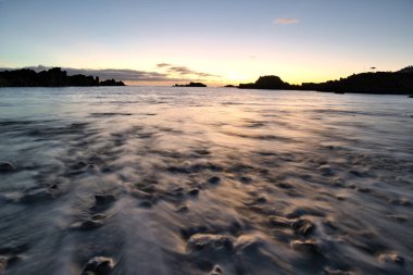Los Cancajos sahilinde gün doğumunda uzun süre çekim, yumuşak su Atlantik kıyısında volkanik kayalara çarpıyor, La Palma, Kanarya Adaları, İspanya